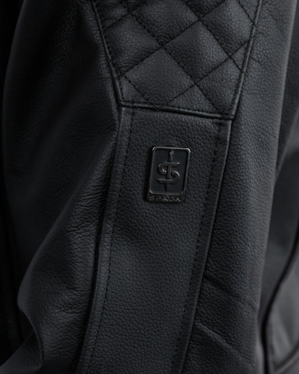 Close-up of a black leather seat with a brand logo on a leather jacket for men