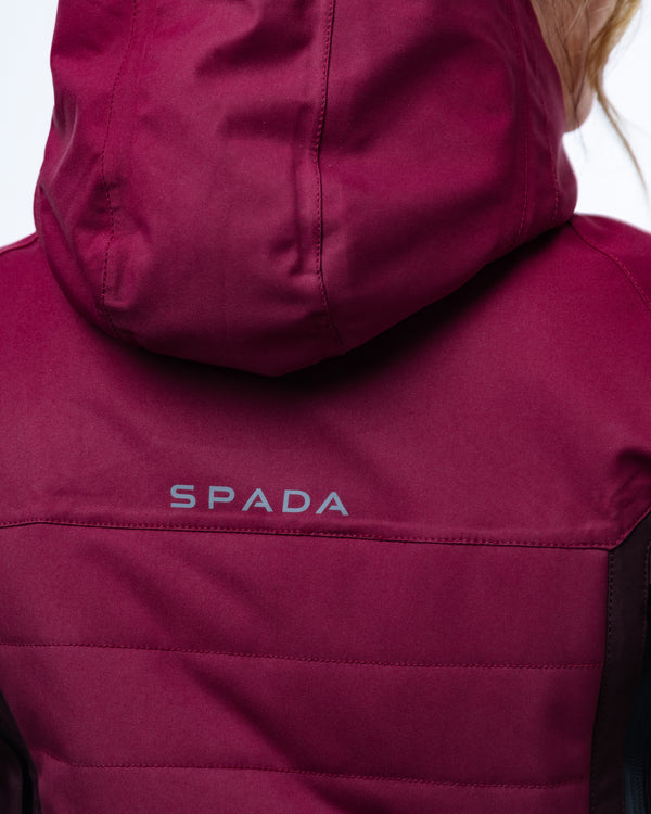 Close-up of a maroon jacket with 'Spada' branding on a blurred background