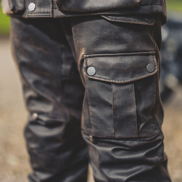 Close-up of biker wearing Crossguard trousers, showing front slant pockets and secure waist fastening