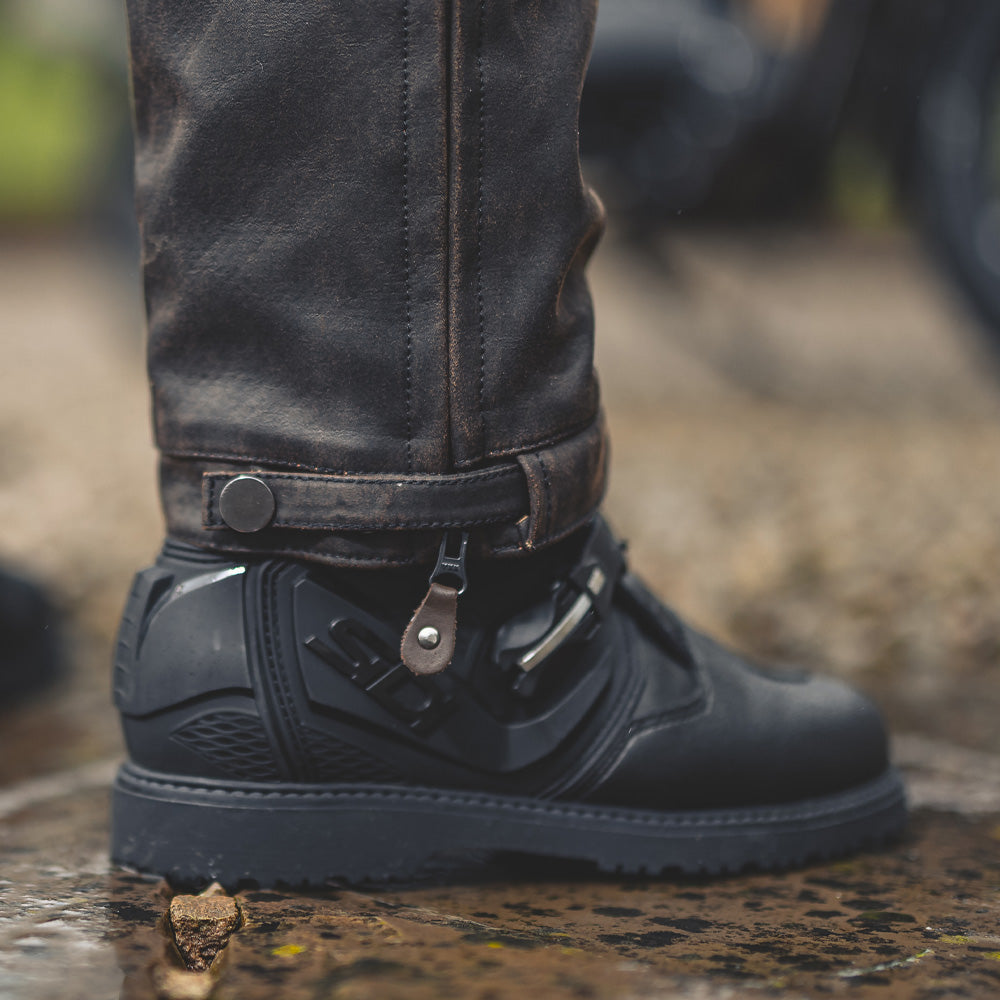 closeup of ankle cuffs and closure on brown motorcycle trousers for men