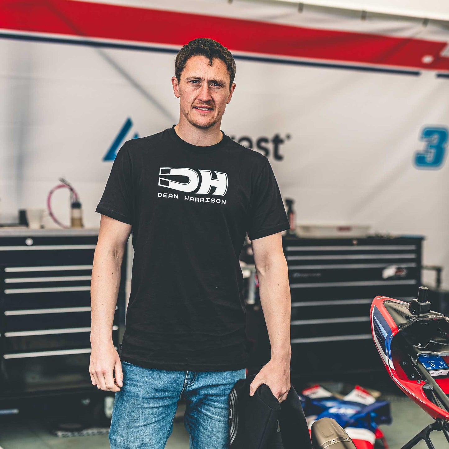 dean harrison wearing his merch t-shirt in a garage setting