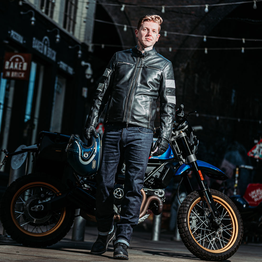 Male biker wearing Hanzo jacket standing by motorbike with helmet in hand – sleek, protective riding gear