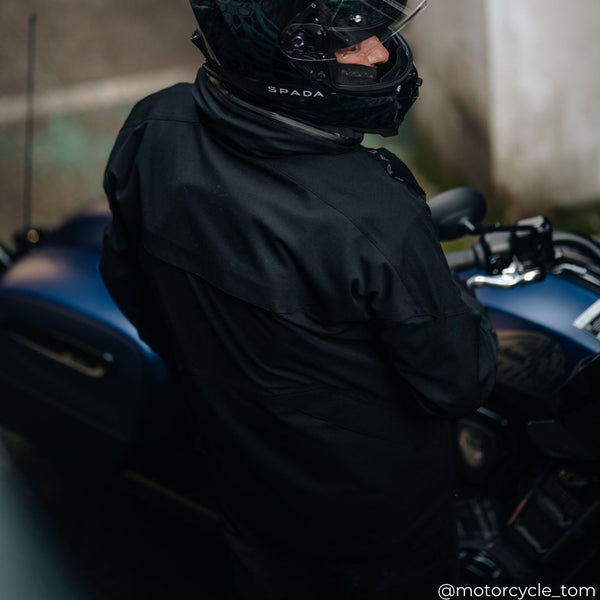 back of biker wearing black waterproof motorcycle jacket with matching spada full face helmet