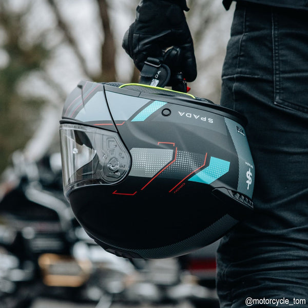 biker holding black and blue flip up motorbike helmet for a ride