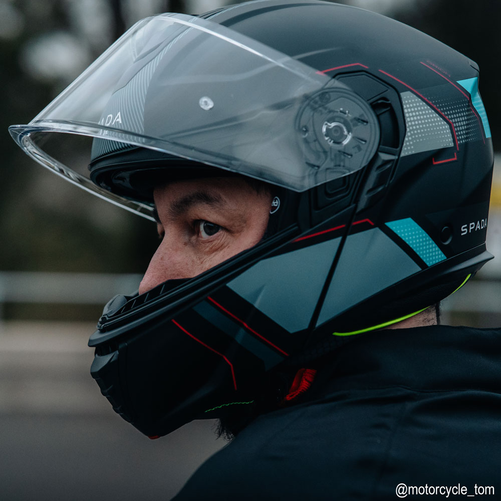biker wearing black and blue flip up motorbike helmet