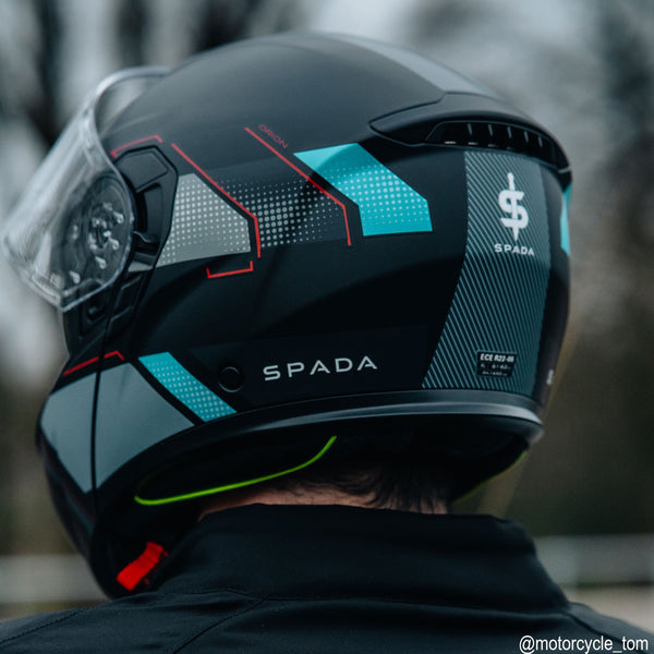 back of biker wearing black motorbike helmet with grey red and blue details
