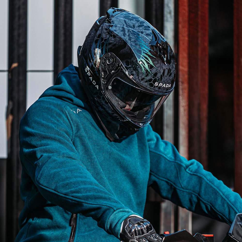 biker wearing black and green motorbike full face helmet with drop down visor