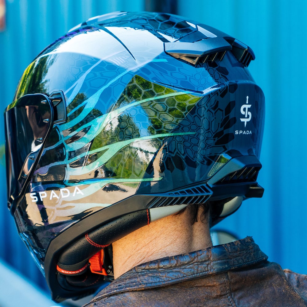 back of biker wearing dark chameleon spada helmet with logo on back
