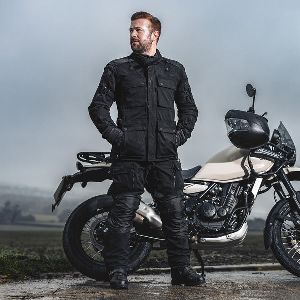 biker wearing full adventure riding gear with black jacket for men and motorcycle trousers