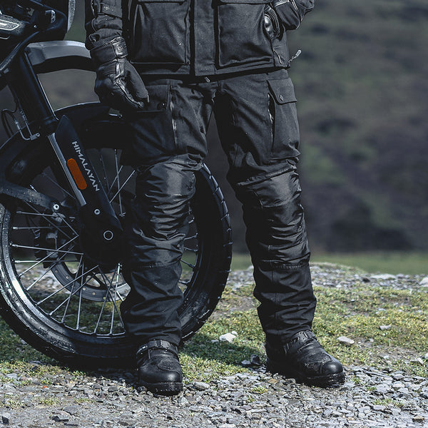 biker in full black waterproof motorcycle gear with waterproof riding trousers