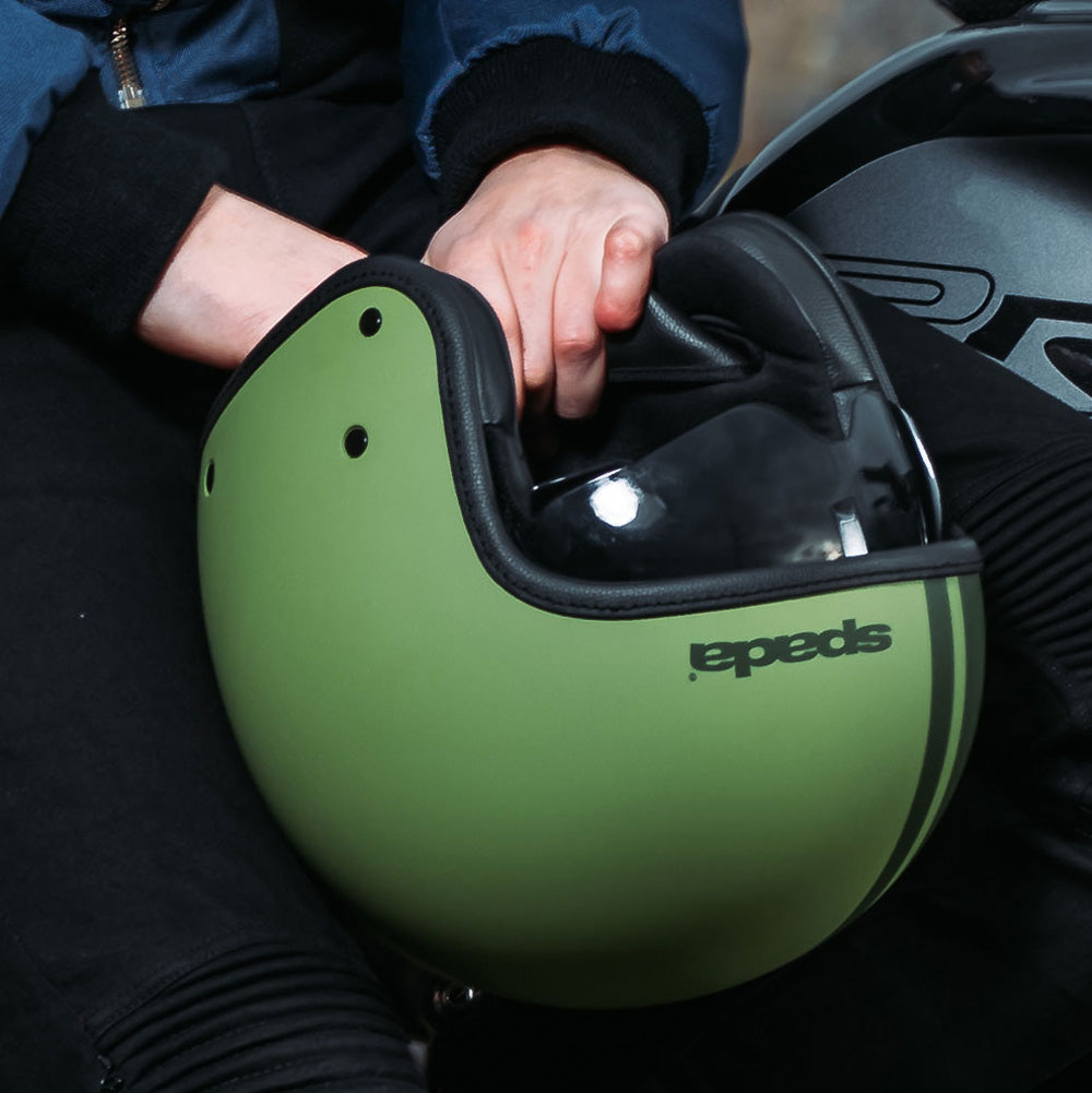 biker holding his matt green open face motorbike helmet