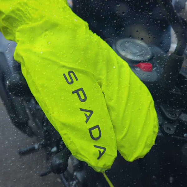 biker wearing yellow fluorescent motorcycle overmitts in the rain