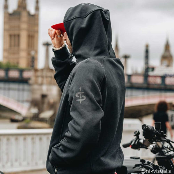 Side and back view of biker in Blade Black motorcycle hoodie with iconic London bridge behind – street-tested urban biker hoodie