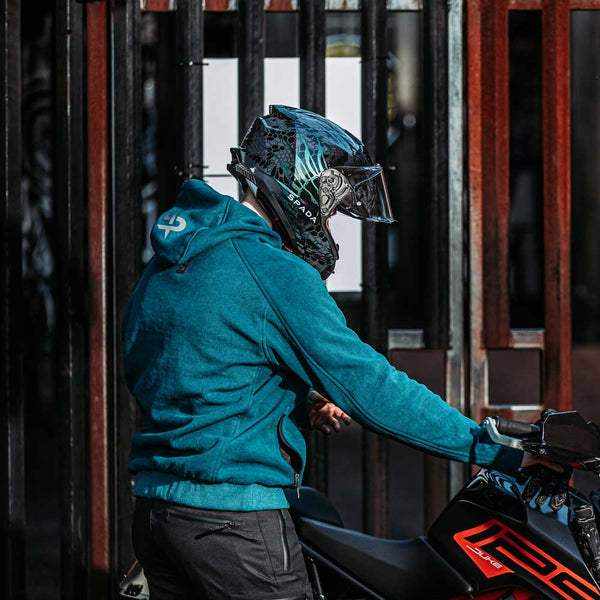 Side angle of man wearing armoured Blade Blue motorbike hoodie on bike – showing unisex fit and urban rider aesthetic