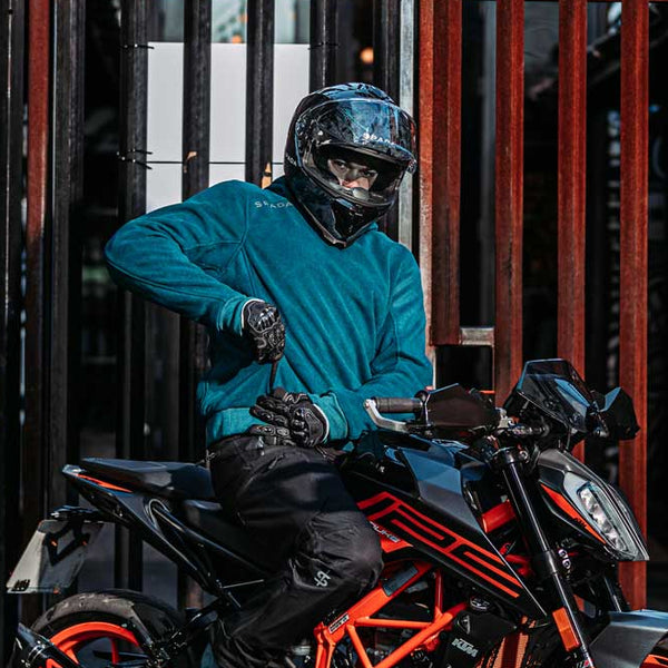 Full body view of male rider in Blade Blue motorcycle hoodie next to orange and black motorbike – street style with biker protection