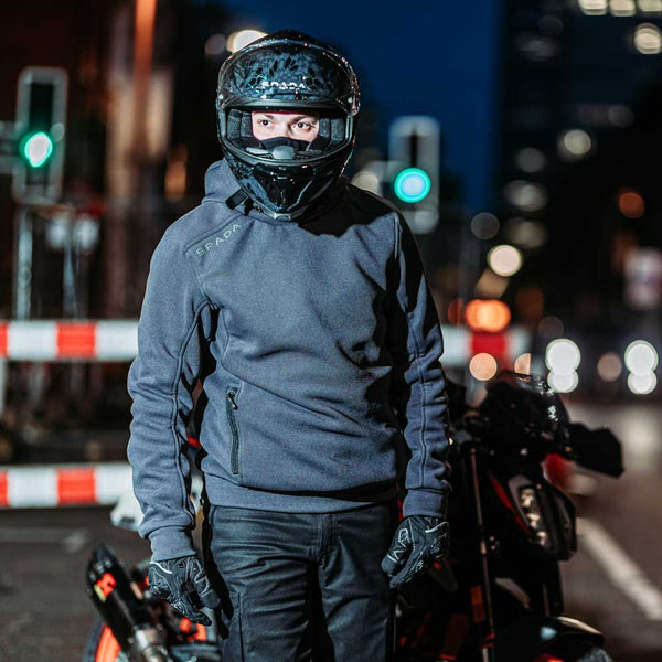 Man wearing Blade Grey pullover hoodie standing beside motorbike – armoured unisex gear blending comfort and biker protection