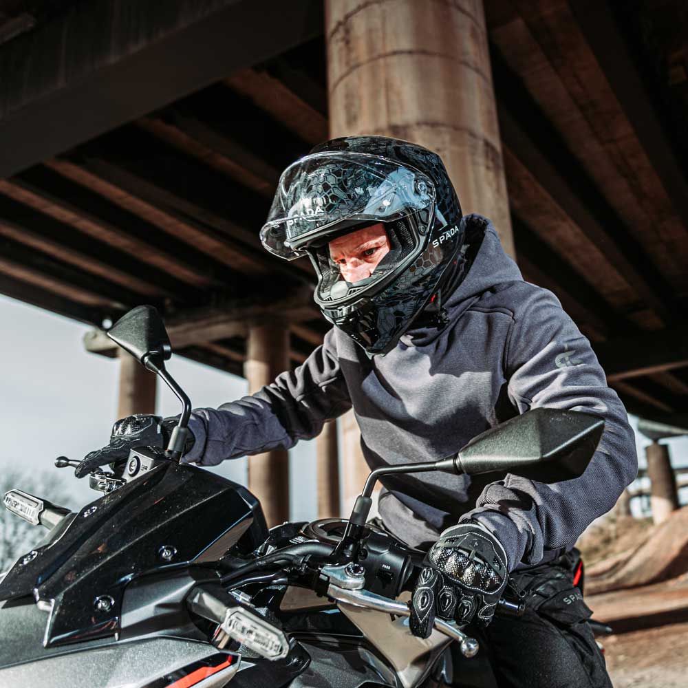 Male biker wearing Blade Grey motorcycle hoodie with helmet while riding – unisex protective gear in action on the road