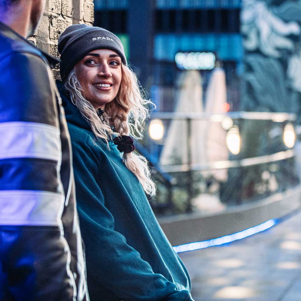 woman wearing blue hoodie with armour in city
