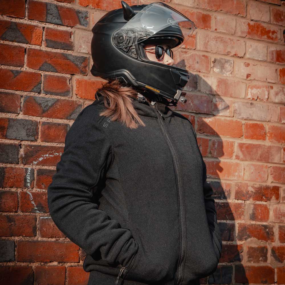 Female biker wearing Blade Black hoodie zipped up with helmet on – sleek unisex protective layer for the road