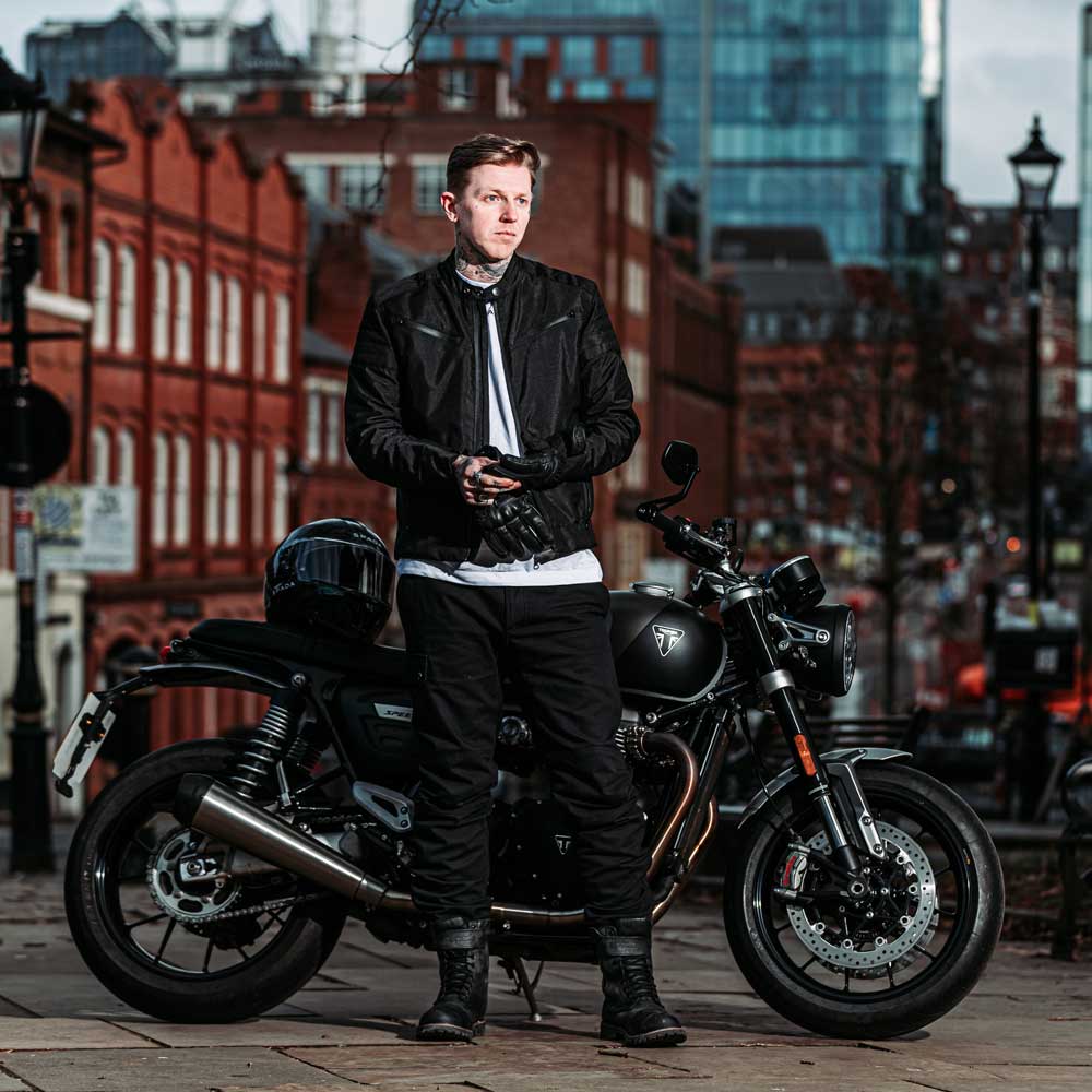 biker wearing full black motorcycle gear with black motorbike in the city