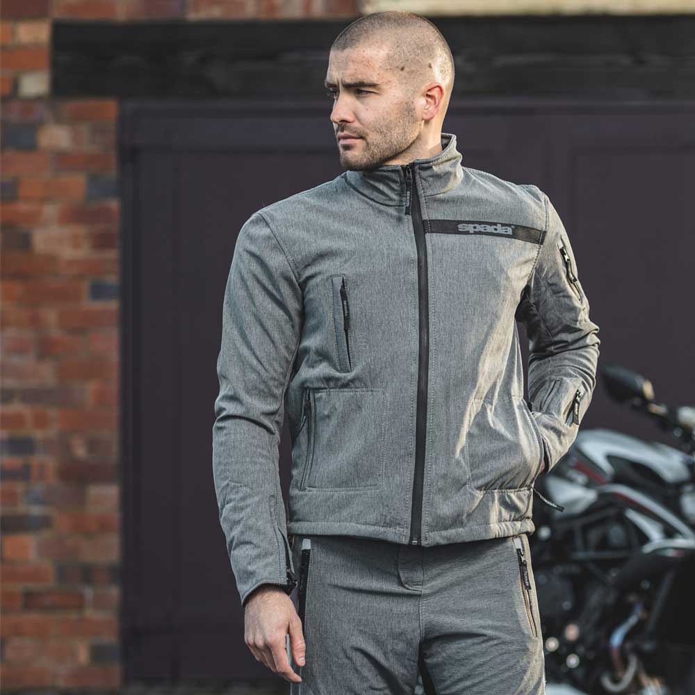 front of biker wearing grey motorbike jacket with storage pockets and motorbike