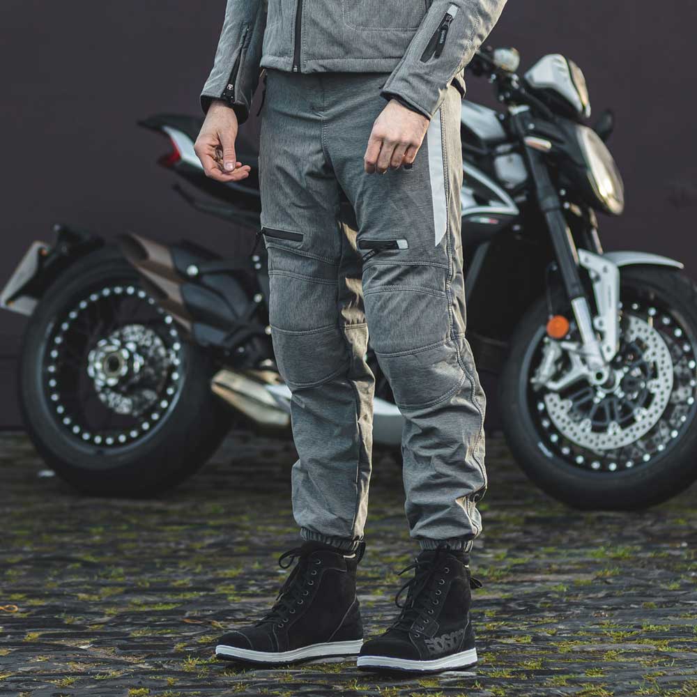 biker wearing grey waterproof motorcycle trousers and jacket with black boots