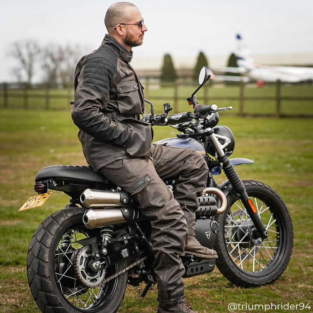 Biker seated on bike wearing Crossguard jacket and matching trousers, combining protection with classic style