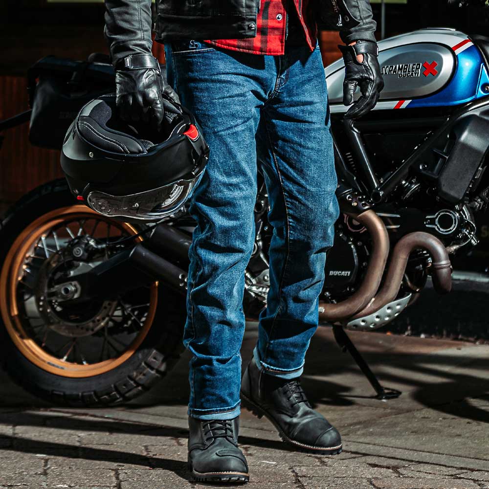 Male biker wearing washed blue Drifters jeans – helmet in hand, ready to ride in protective denim