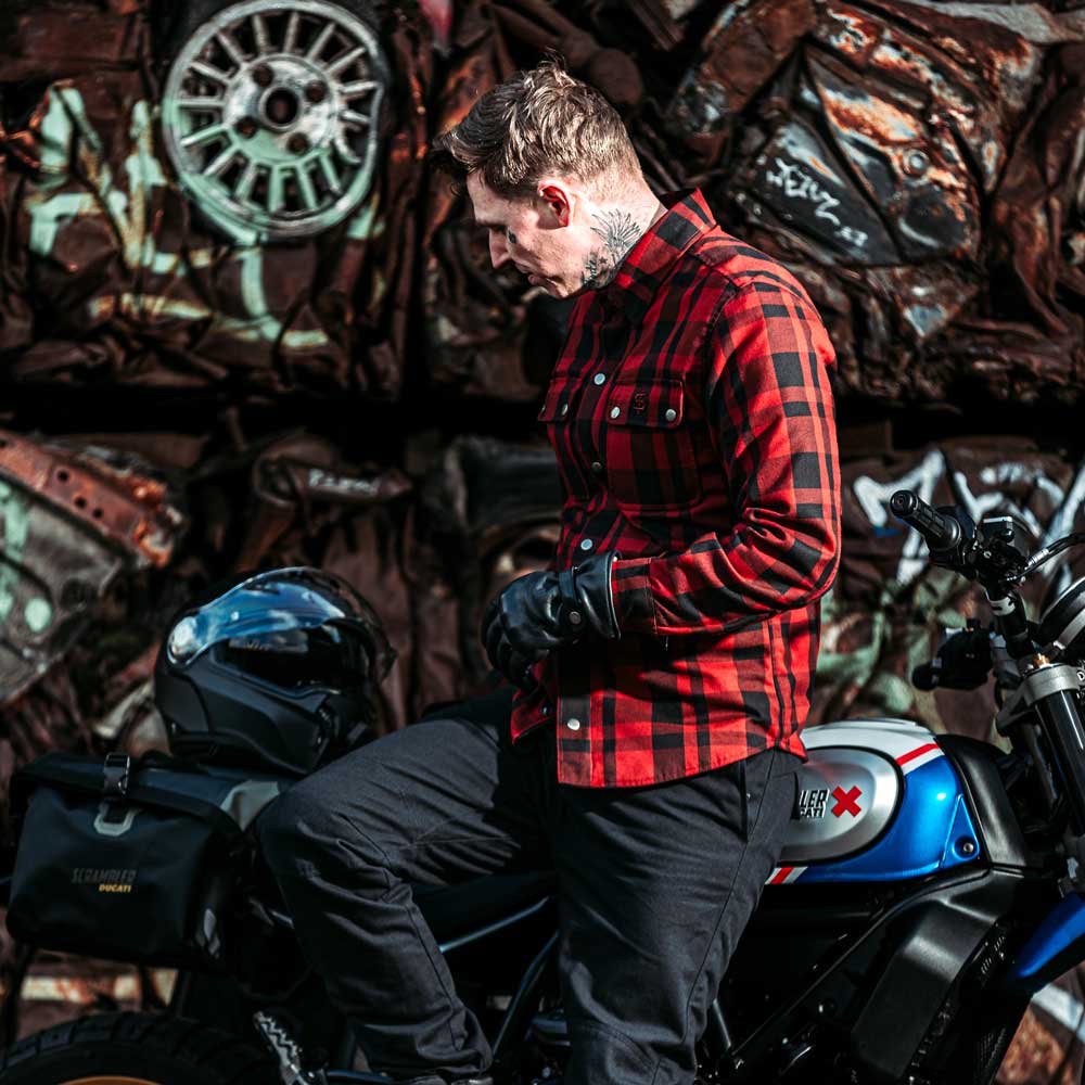biker siting on motorbike wearing black and red button down shirt with armour