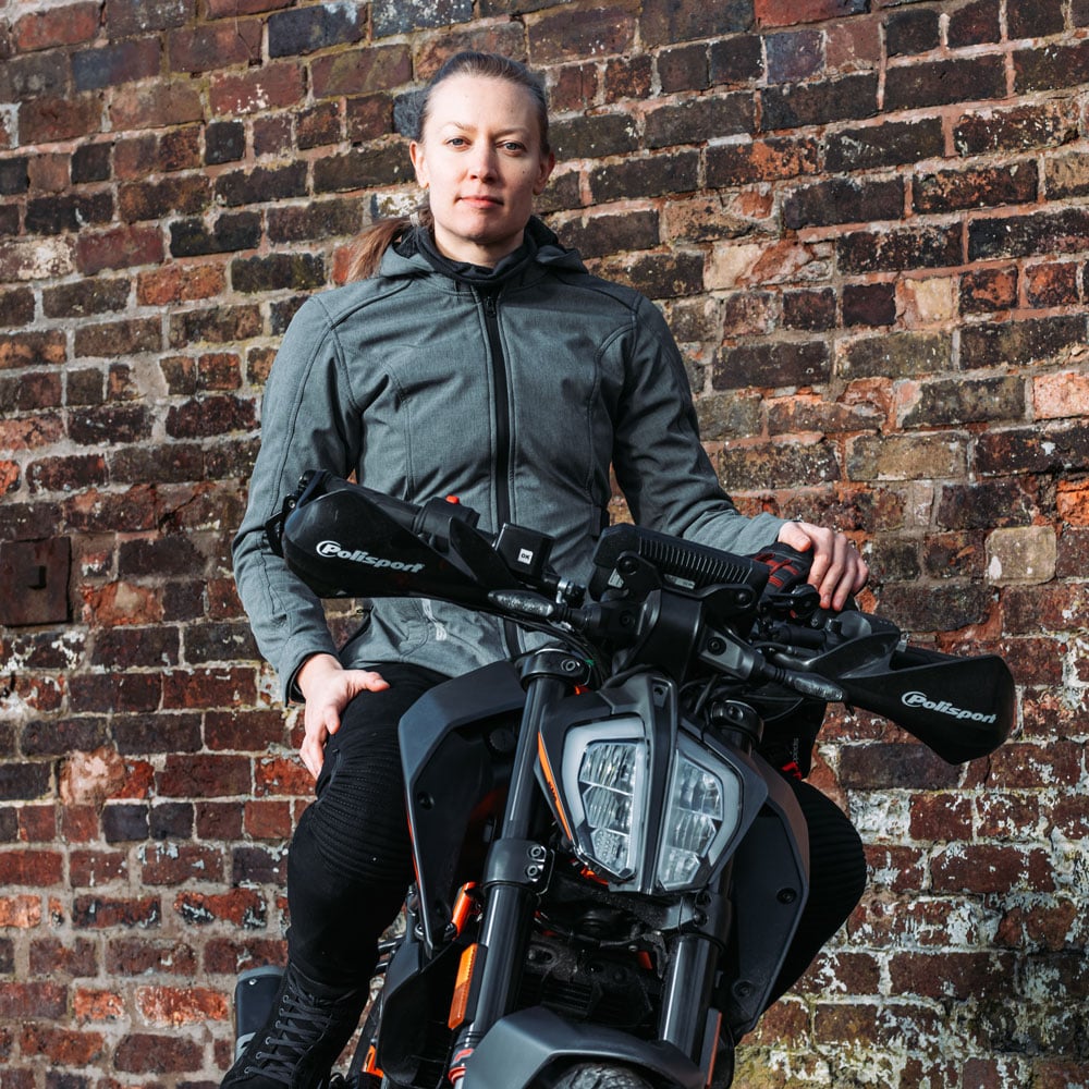 female biker on motorbike wearing a grey waterproof womens motorcycle jacket