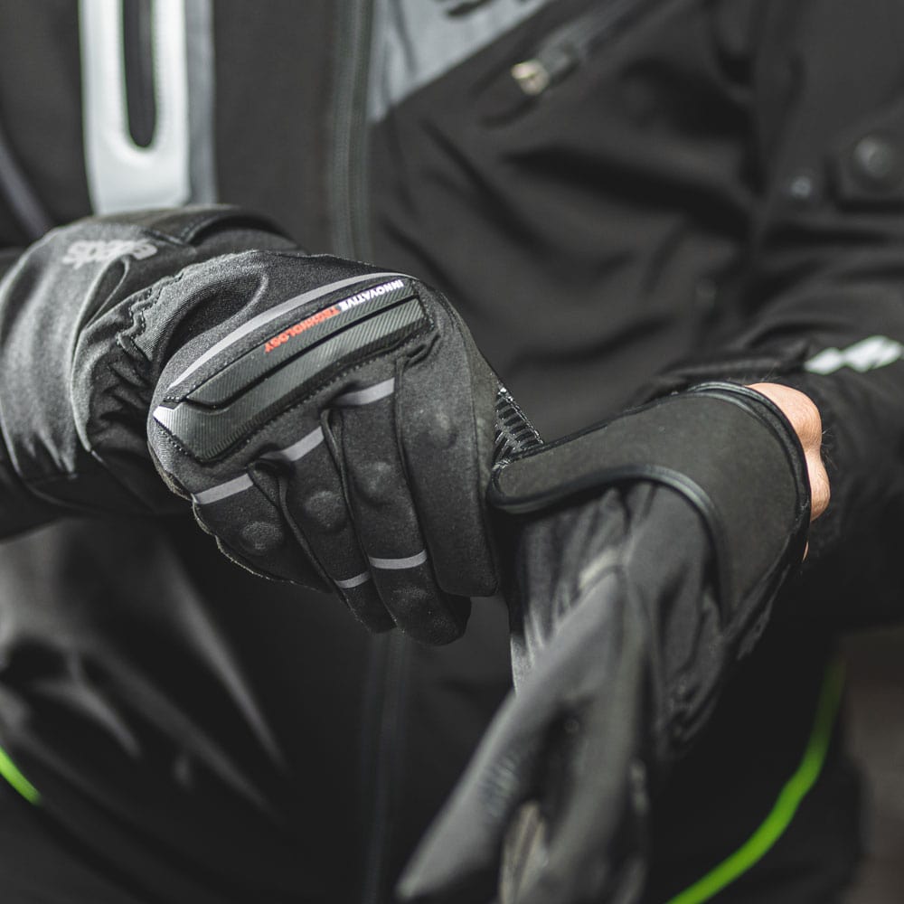 biker putting on taslan amara waterproof motorcycle gloves for women