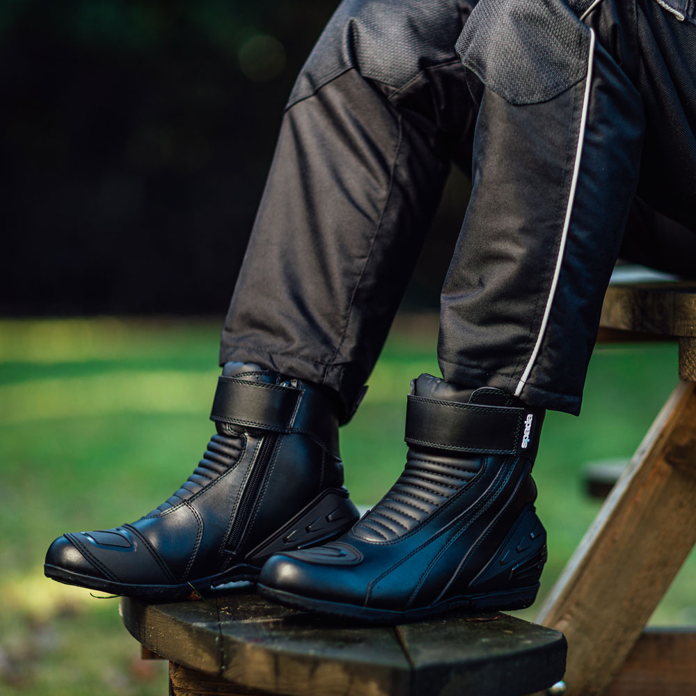 biker wearing a pair of black motorcycle boots with black motorbike trousers