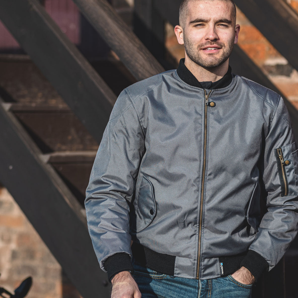 biker wearing grey zip up motorcycle jacket with black cuffs