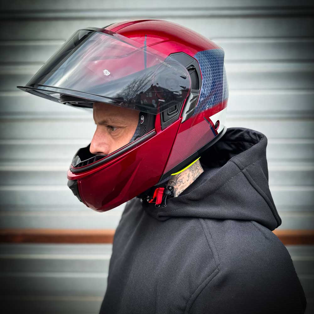 biker wearing red helmet with smoked visor lifted up