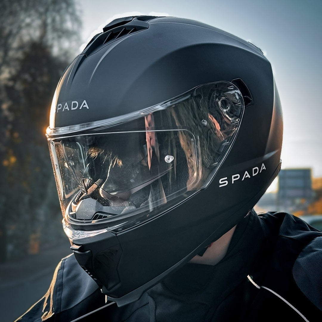 biker wearing all black motorbike helmet with internal sun visor and clear visor