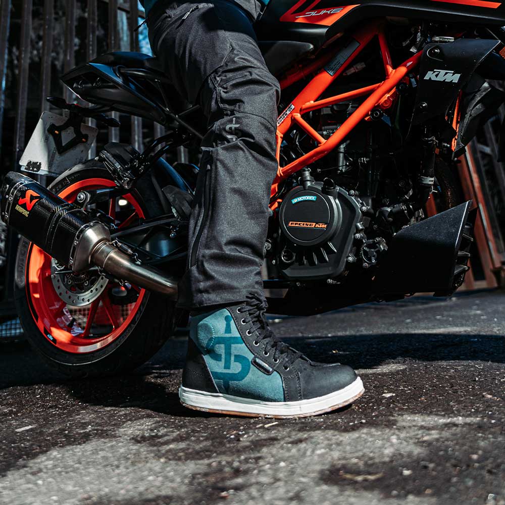 biker wearing black and blue protective trainers