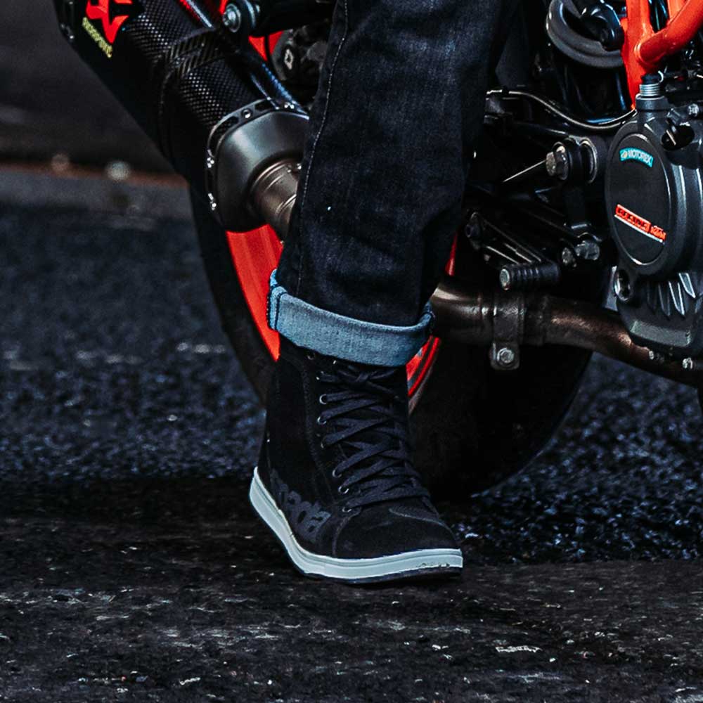 biker wearing black spada strider high top trainers with rolled over riding jeans on bike ride