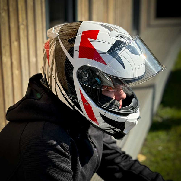 biker wearing white black and red motorbike helmet with clear visor in the sun