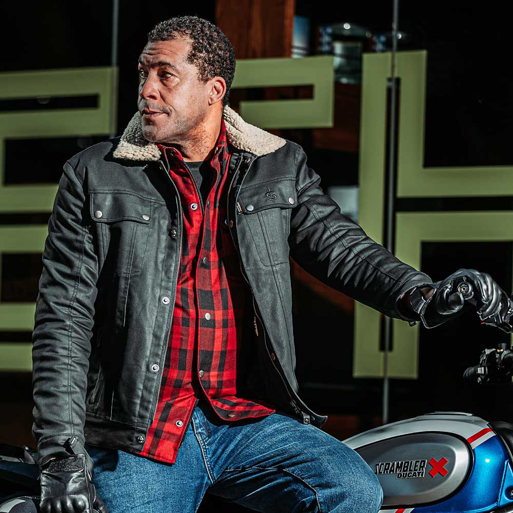 closeup of biker wearing temper trucker spada jacket on motorbike with leather gloves