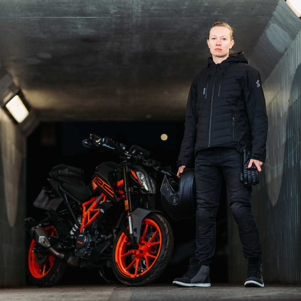 black ladies motorcycle jacket worn by biker girl with motorbike