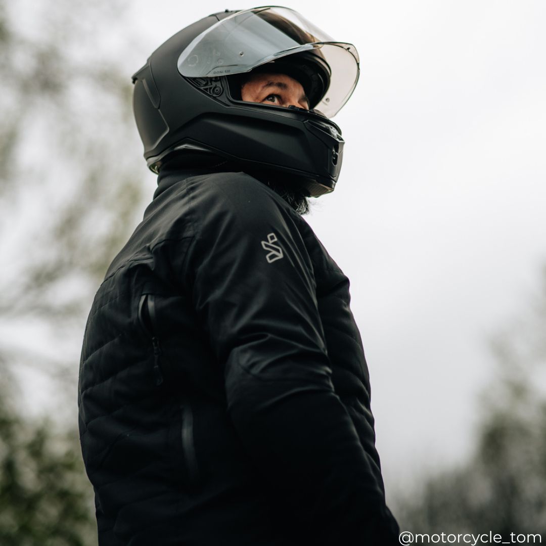 biker wearing black quilted jacket with black motorcycle helmet