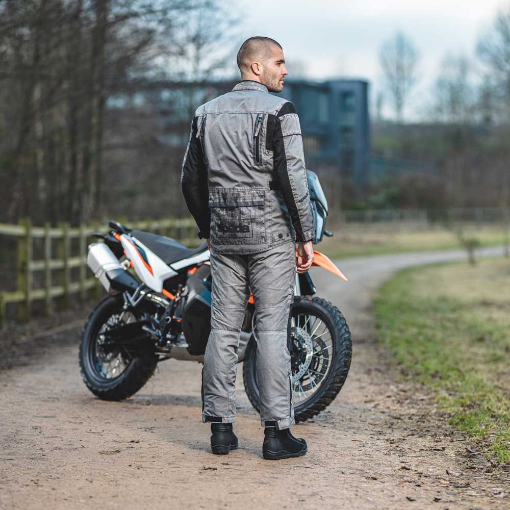 back of biker with motorbike wearing grey protective motorcycle gear