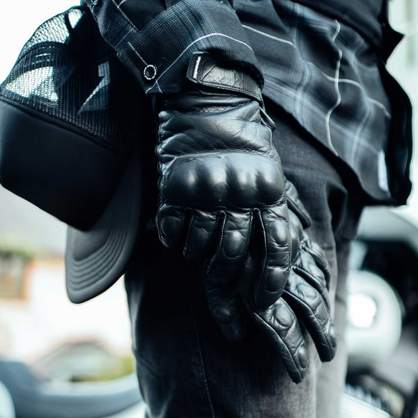 biker wearing black leather motorcycle gloves