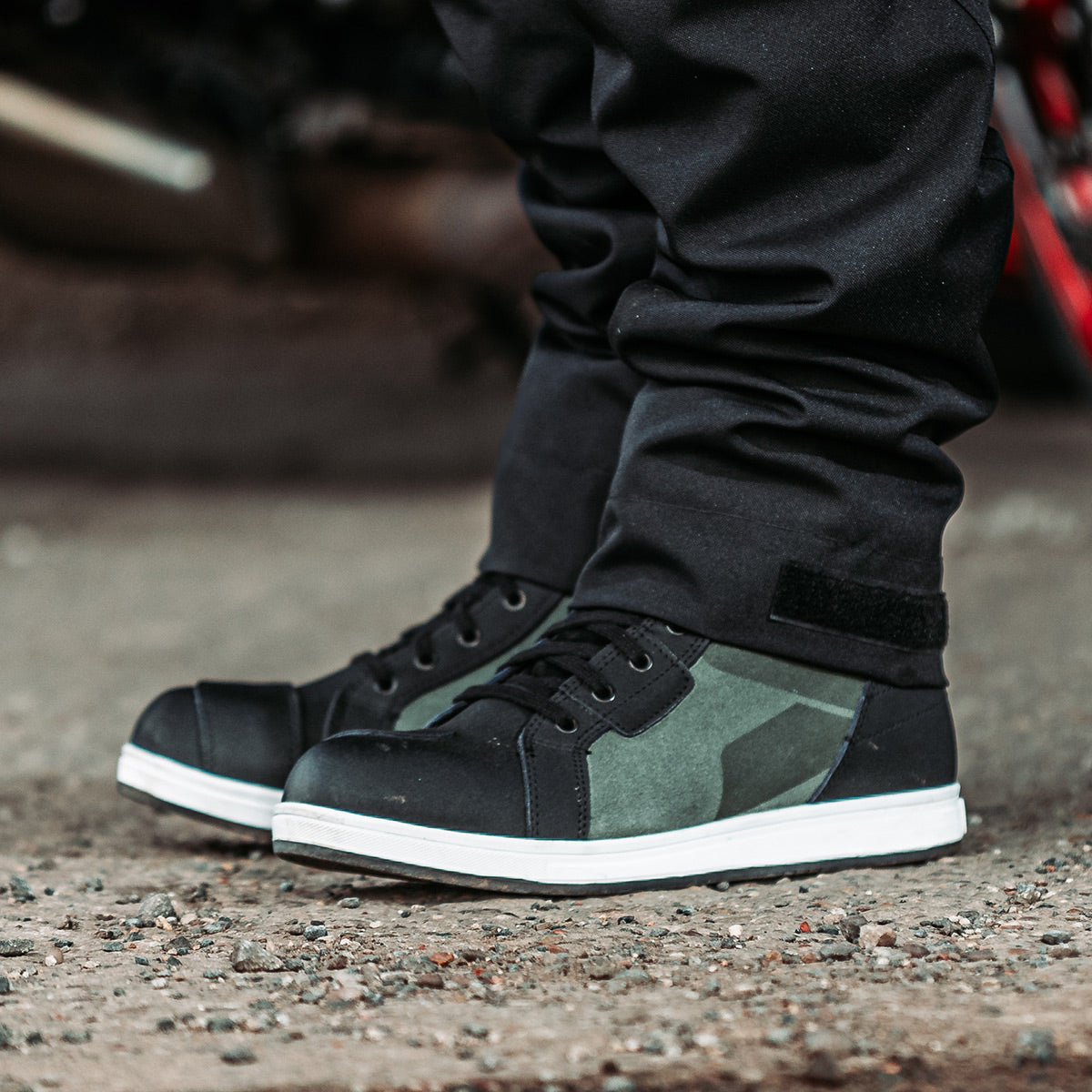 biker wearing a pair of black and green suede lace up high top motorbike boots