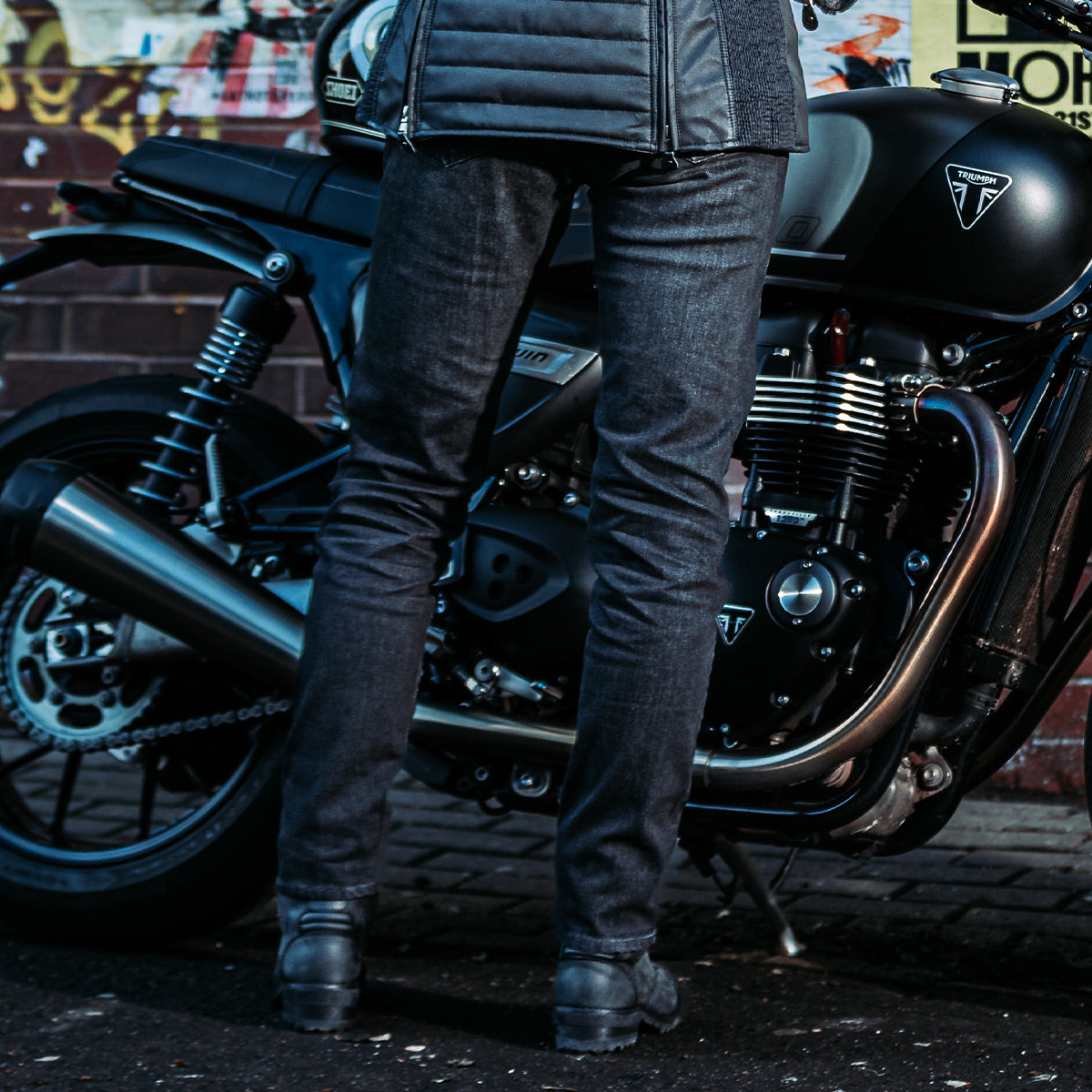 Rear view of a woman wearing black washed motorcycle jeans, highlighting the tailored fit and casual yet protective style for ladies.