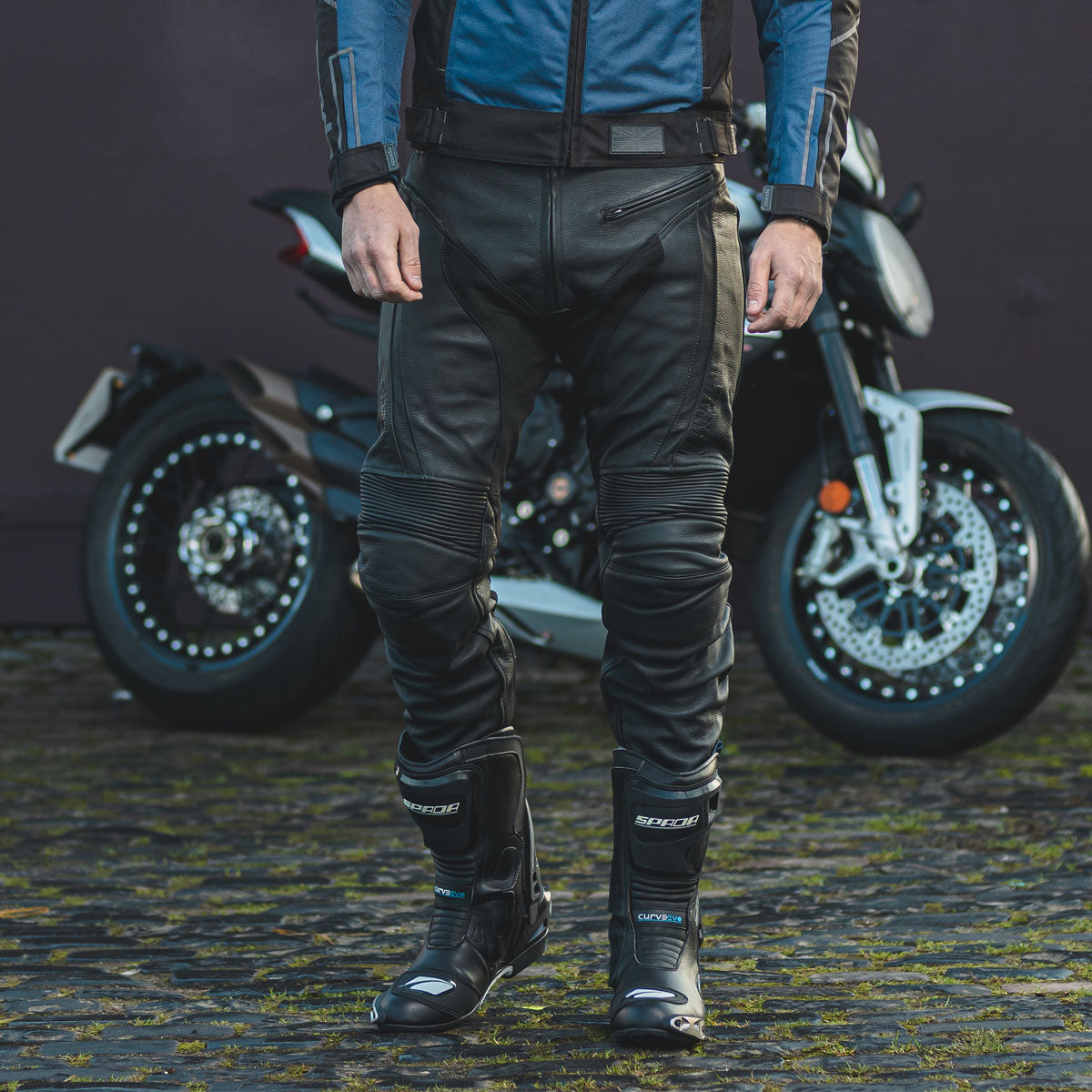 biker wearing black riding jeans for men with black touring spada boots