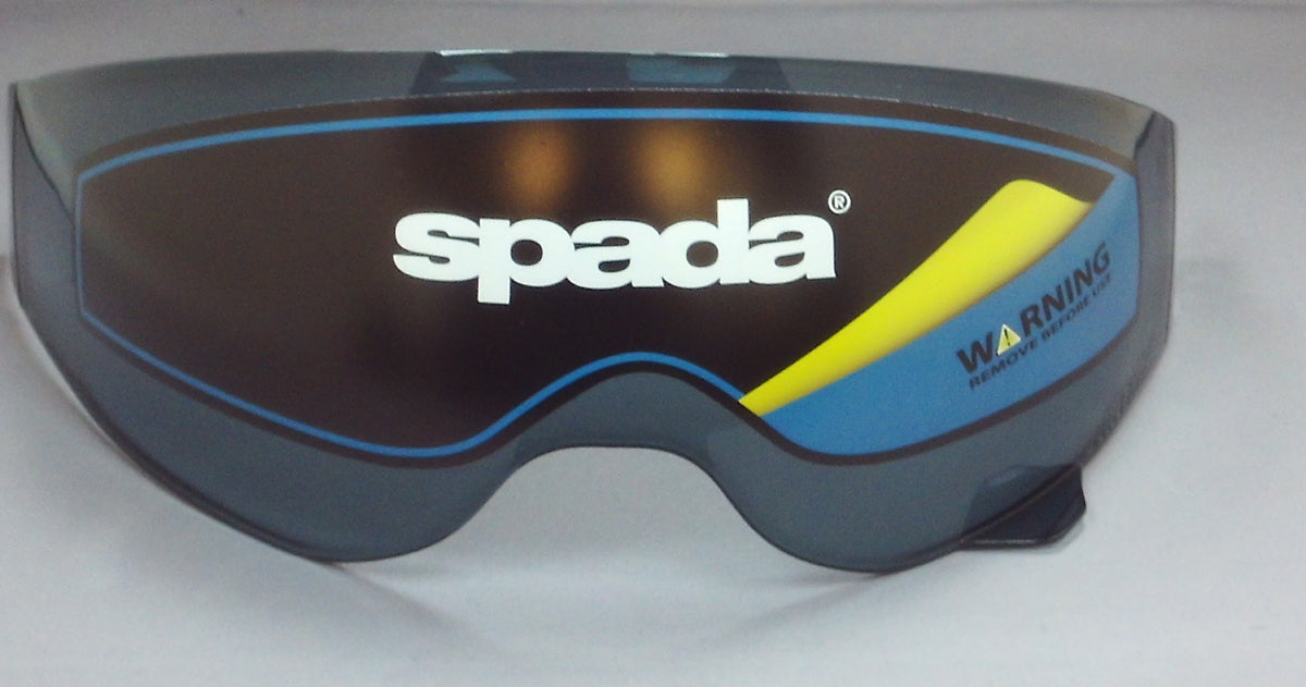 A dark smoke tinted visor for a Spada Storm motorcycle helmet, with the Spada logo and 'WARNING' text on the lower right corner.