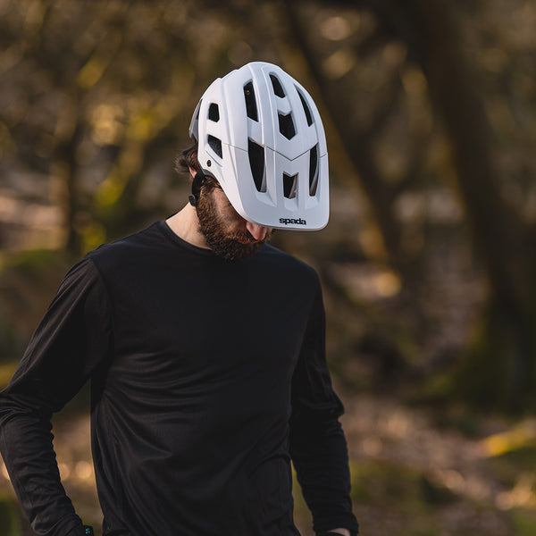 biker wearing white mtb helmet paired with shirt in the outdoors