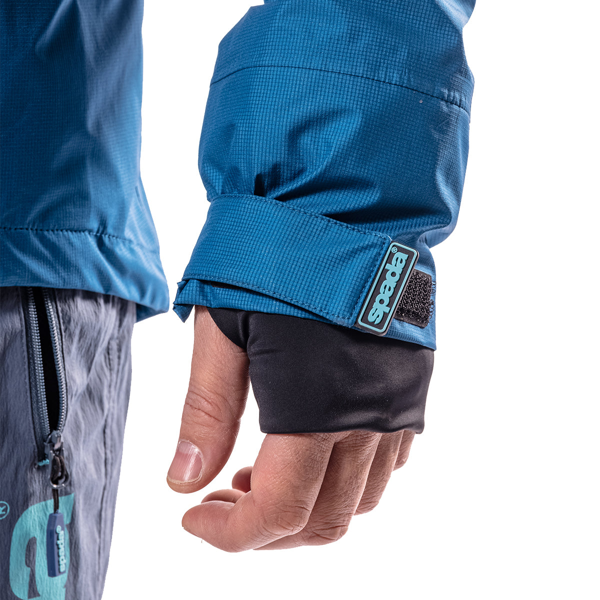 closeup of cuffs of blue waterproof jacket with thumb holes