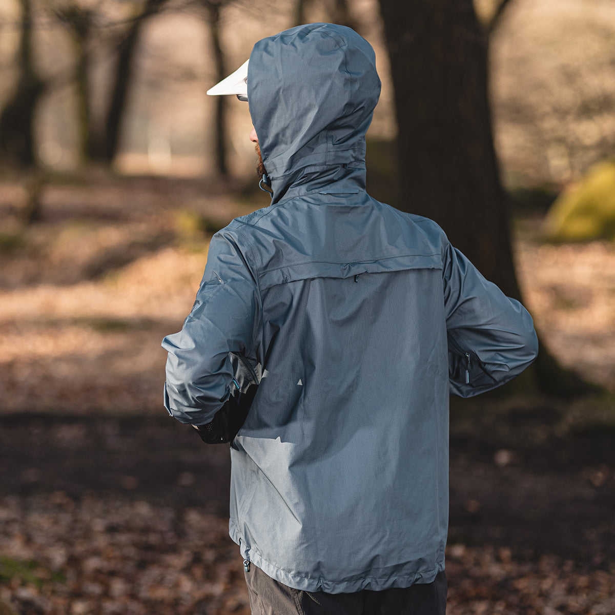 back of biker in the outdoors wearing waterproof jacket over helmet